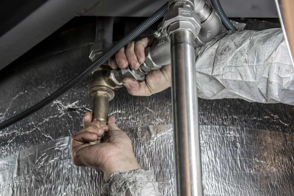 A plumber's hands fitting steel pipework during a job